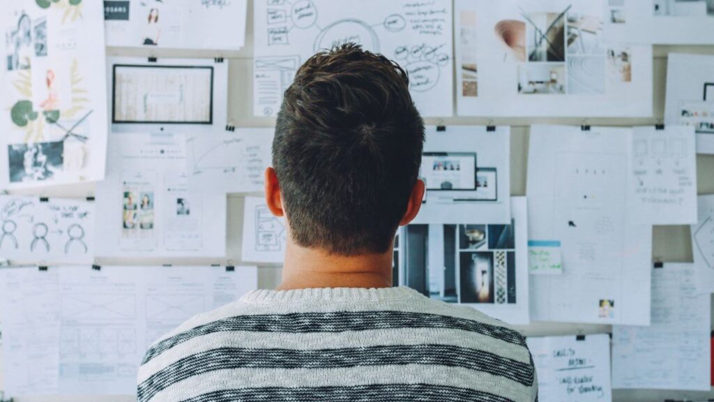 Empreendedor jovem em um escritório moderno, analisando gráficos e ideias em um quadro